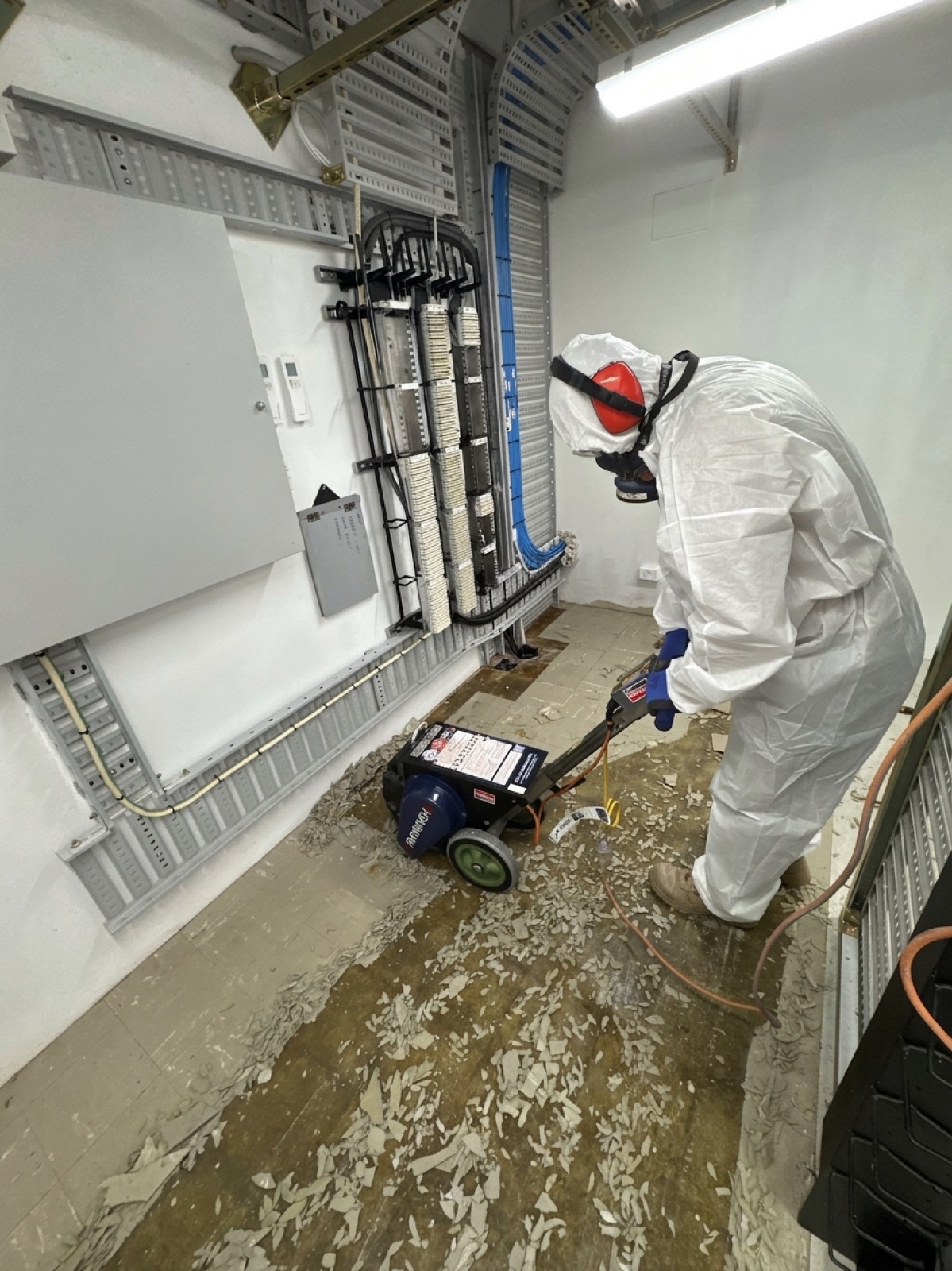 Operator removing asbestos vinyl flooring, University of Sydney Camden campuses